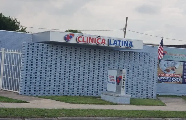 Storefront of Clínica Latina Corpus Christi with the sign, the 1620 address and the walk-ins banner