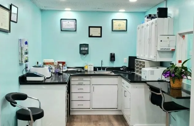 Lab room with a work countertop, stools and framed diplomas on the wall