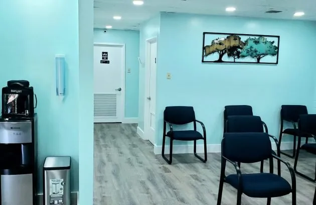 Waiting area with a water and coffee dispenser next to the hallway to the exam rooms