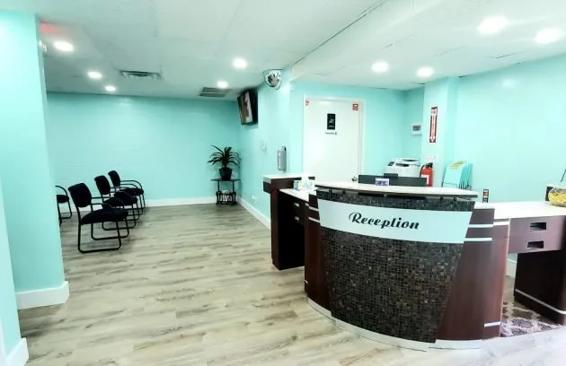 Front desk of Clínica Latina with the reception counter and the waiting area in the back