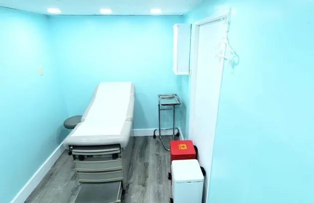 Exam room with an exam table and an instrument cart