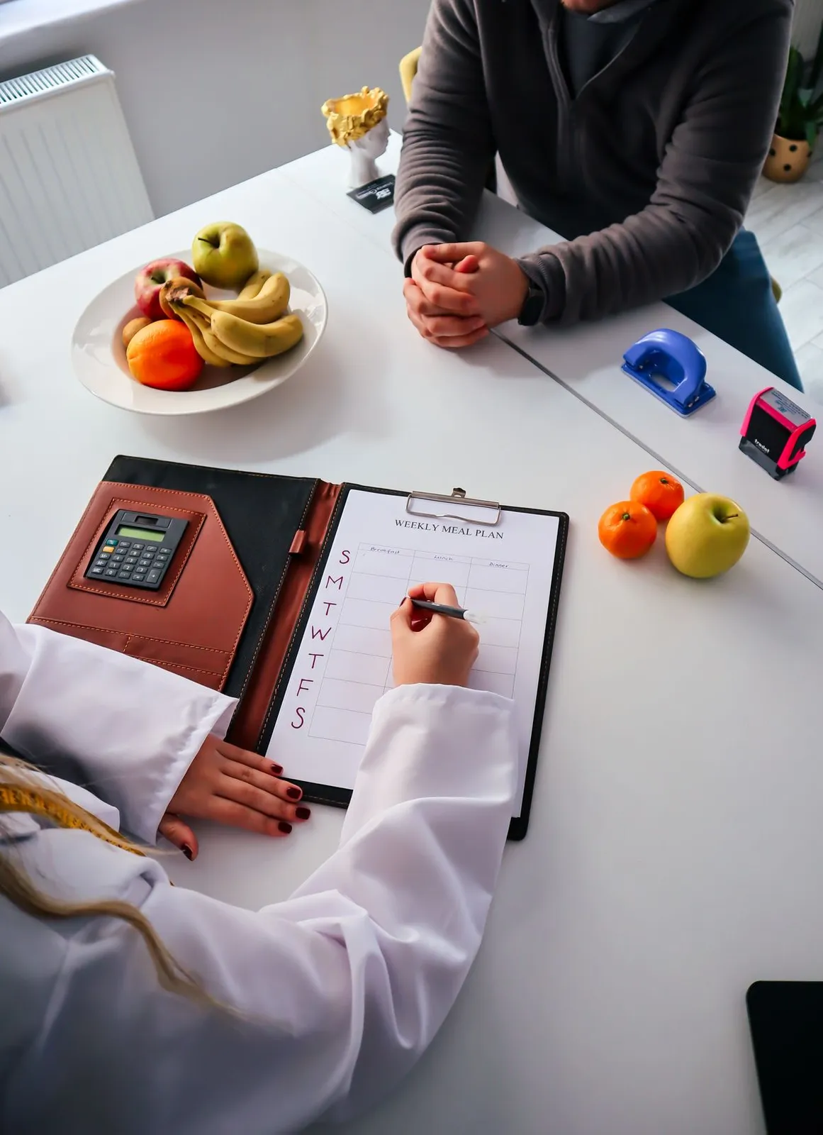 Nutritionist preparing a healthy meal plan with fresh fruit